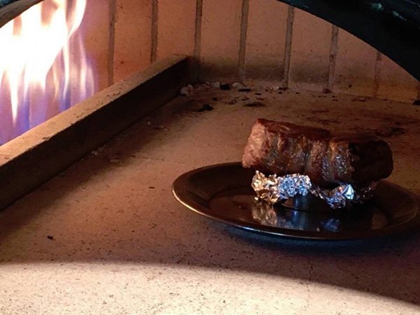 遊ぶたのロース肉を高温の薪釜の中に入れ、時々休ませながら、じっくりと火を入れていきます