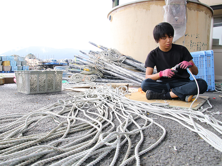 ロープとロープを結び目なく繋いだり、輪っかにしたりする「綱さし」をする磯島さんの写真