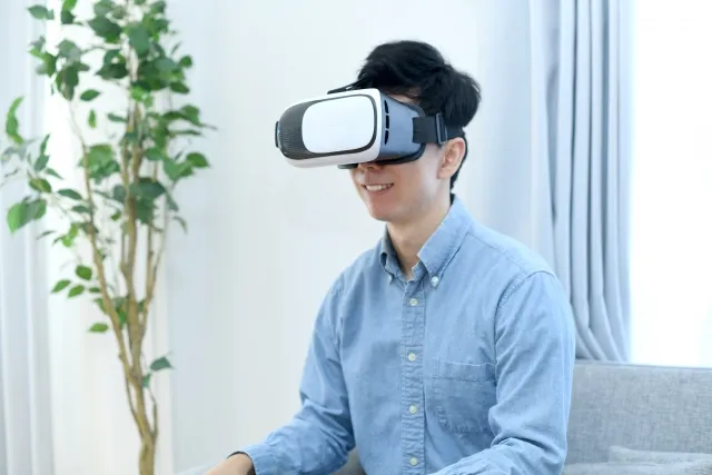 男性がVRゴーグルをかけて農業ゲームをプレイする様子