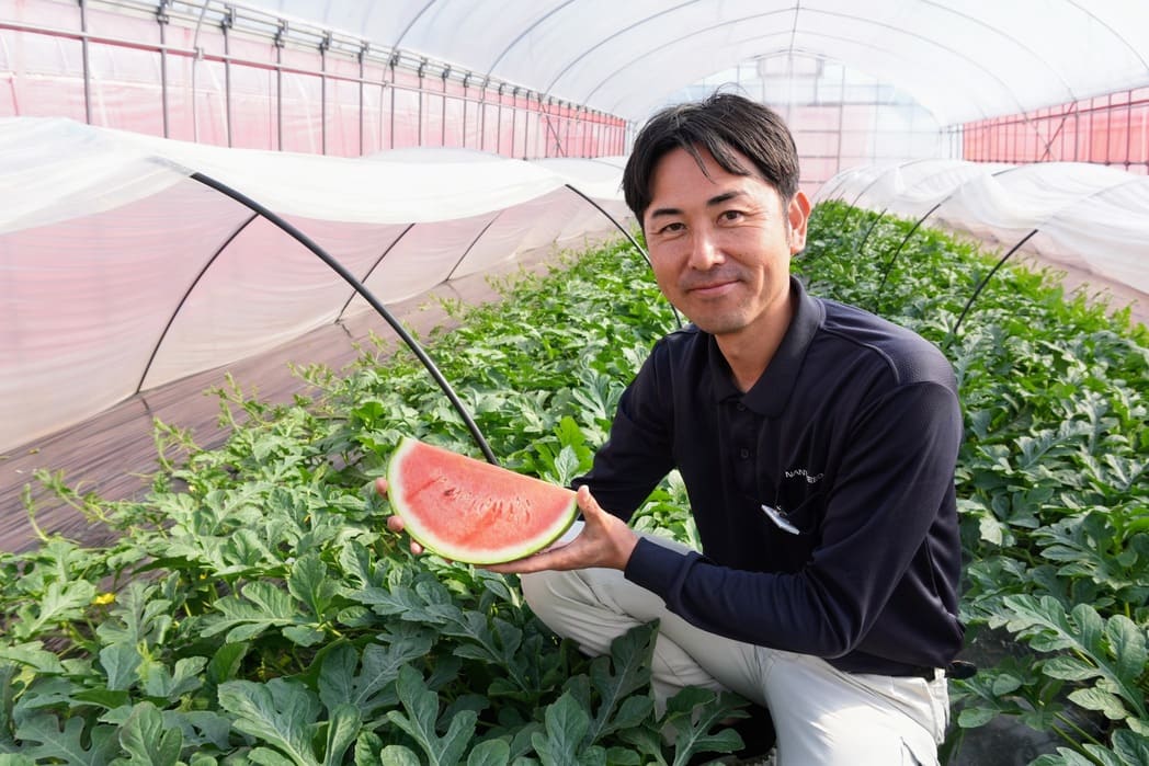 宇野さん 切ったスイカを持ち上げて微笑んでいる様子